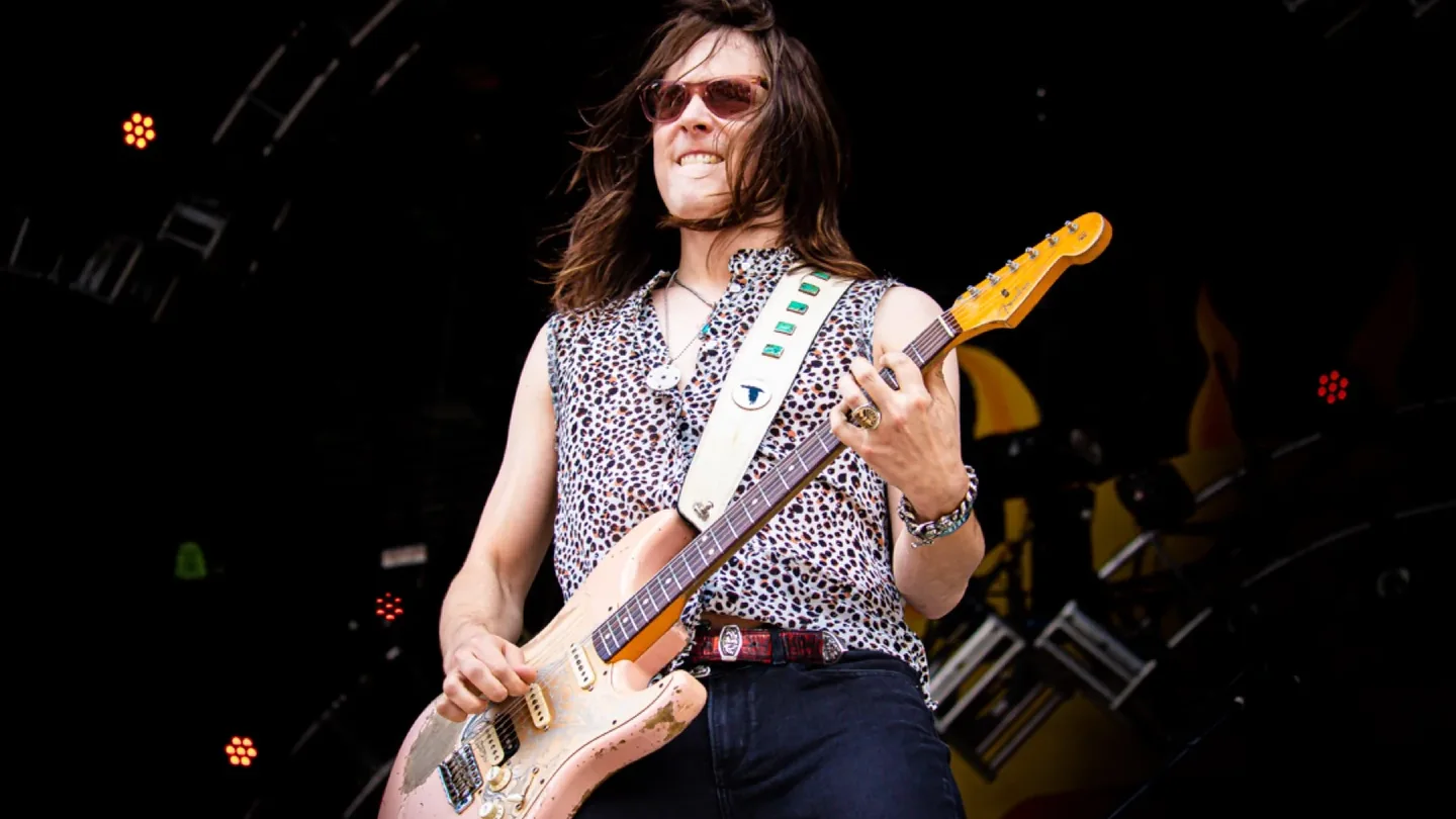 Guitarist performing on stage under festival lights
